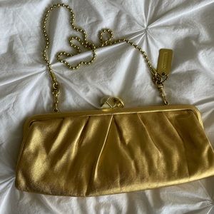 Gold leather Coach clutch with bath bead strap